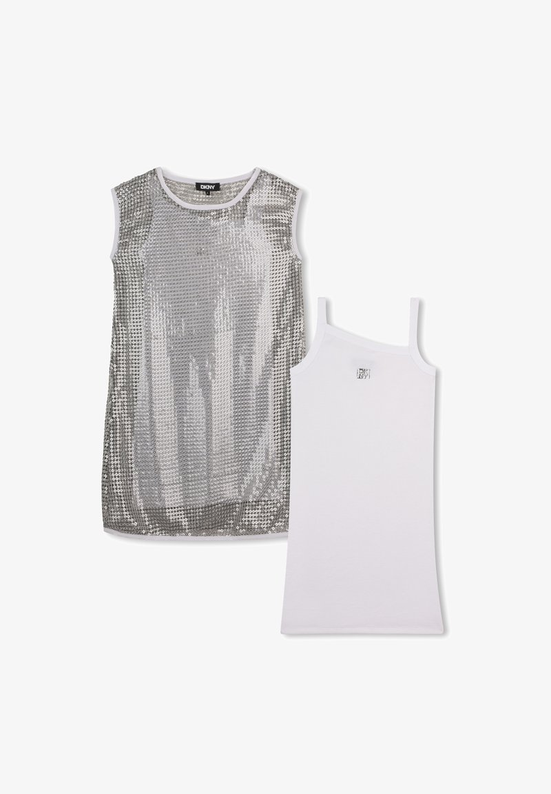 Robe sans manches en sequins argentés associée à un débardeur blanc sans manches, tous deux de DKNY, présentés sur un fond blanc.