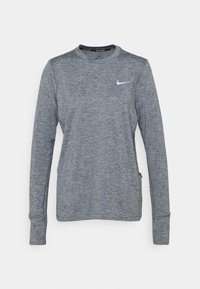 Harmaa pitkähihaisen urheilupaita, joka on valmistettu kosteusohjaavasta kankaasta. Paidassa on pyöreä pääntie ja pieni valkoinen Nike-logo rintamuksessa.