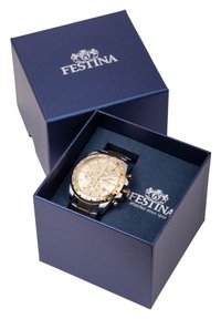 Festina ručni sat s zlatnim i srebrnim akcentima, crnim remenom, prikazan u tamnoplavoj kutiji s Festina logotipom na unutarnjoj oblozi.