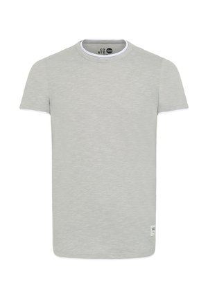 Světle šedé tričko s krátkým rukávem a kulatým výstřihem, se bílým akcentem na krku a malou nášivkou vlevo dole.