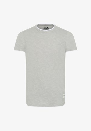 Světle šedé tričko s krátkým rukávem a kulatým výstřihem, se bílým akcentem na krku a malou nášivkou vlevo dole.