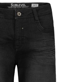 Black denim jeans featuring a classic design with a zip and button closure, front pockets, and subtle stitching details. Size 32.