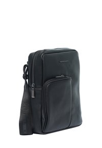 Borsa a tracolla nera in pelle con finitura testurizzata, due tasche con zip e una tracolla regolabile con dettagli del marchio.