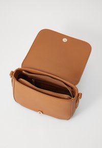 Borsa a tracolla in pelle marrone con chiusura a scatto magnetico, scomparti interni con zip e una texture liscia.