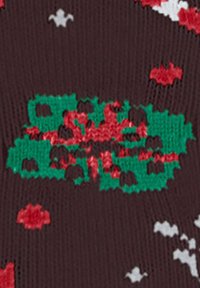 Strickmuster mit einem dunkelbraunen Hintergrund, grünen und roten Formen sowie kleinen weißen Akzenten, die ein strukturiertes Erscheinungsbild erzeugen.