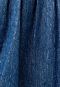 Denim fabric in deep blue with a smooth texture, featuring subtle variations in weave and color, creating a distinct, durable appearance.