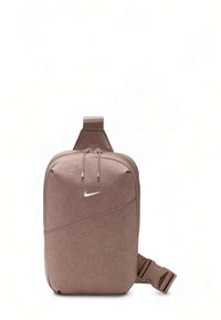Borsa a tracolla Nike color marrone chiaro con doppia cerniera, logo bianco sul davanti, tracolla regolabile e fibbia in plastica su sfondo bianco.