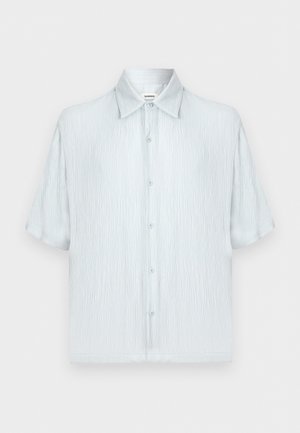 Chemise homme bleu clair à manches courtes en tissu texturé, col classique et fermeture boutonnée devant sur un fond uni.