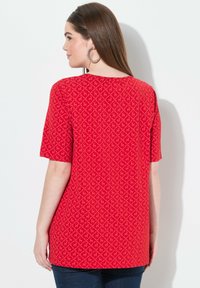 Top corto rojo de manga corta con un patrón de diamantes y un corte relajado, hecho de un tejido ligero. La parte posterior es lisa con un escote redondeado.