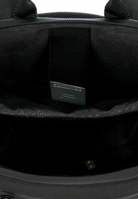 Zwarte tasinterieur met textuurstof, verstelbare banden en een USB-poort. Bevat een gaasvak en hexagonale patroon detailing.