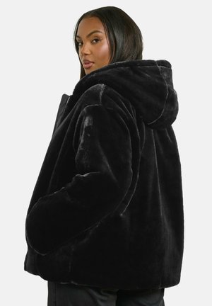 Sort faux fur hættejakke med løs pasform. Har store lommer og en blød, tekstureret overflade. Lynlås lukning foran.
