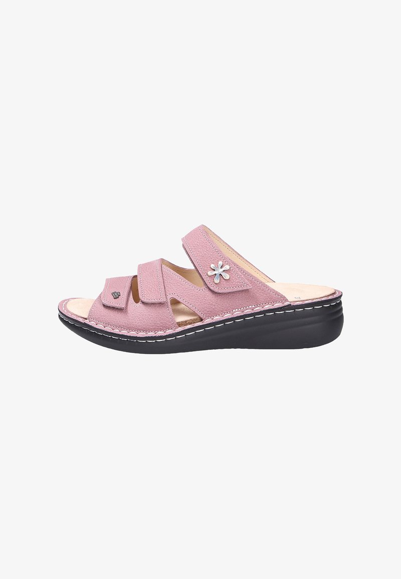 Pink open-toe sandal with three adjustable straps, a small flower decoration, cushioned beige insole, and black sole with white stitching.
