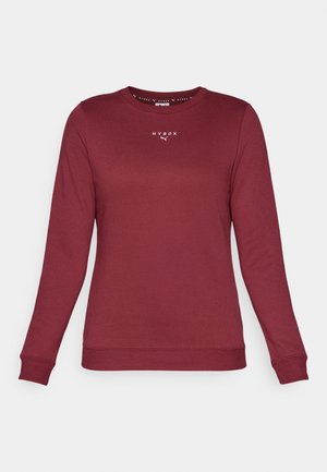 Bordeaux langærmet sweatshirt lavet af blødt materiale, med rund halsudskæring og broderet logo på brystet. Ribbenede manchetter og kant.