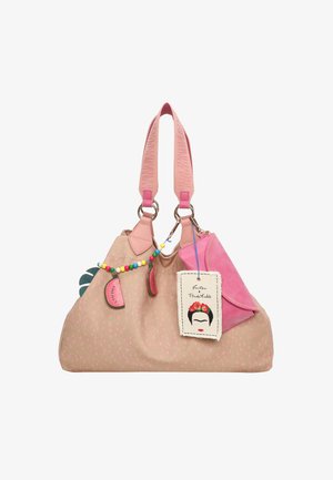 Grote roze en beige handtas met stippenpatroon, dubbele roze hengsels en kleurrijke charm-accenten, waaronder een label met een geïllustreerd gezicht.