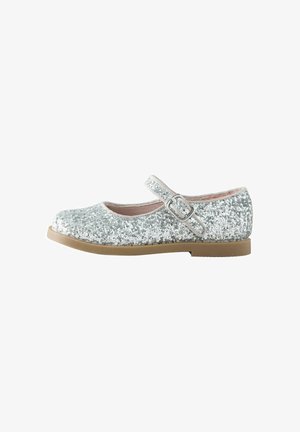 Zapato Mary Jane plateado con purpurina, punta redonda, tira con hebilla y suela de goma marrón. Presenta un forro interior suave de color rosa.