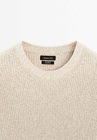 Pull en coton beige tricoté avec col rond côtelé et étiquette de marque "Massimo Dutti" visible à l'intérieur du col.