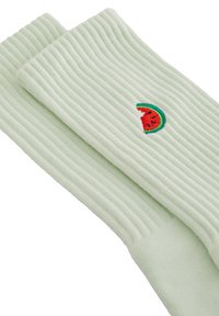 Gerippte, hellgrüne Socken mit einem kleinen gestickten Wassermelonen-Motiv in Rot und Grün. Weiche Textur und mittellange Design bis zur Wade.