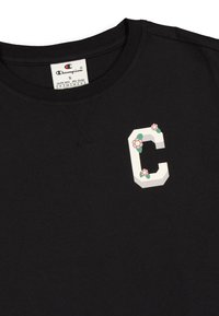 Felpa nera in cotone con colletto rotondo, caratterizzata da un design geometrico a "C" con accenti floreali sul petto. Texture morbida, vestibilità casual.