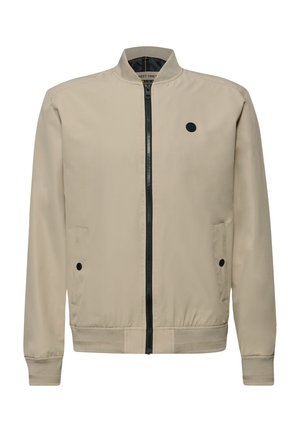 Beige bomberjack met zwarte voorrits, geribde kraag en manchetten, twee zakken met drukknoop, en een klein rond zwart logo op de borst.