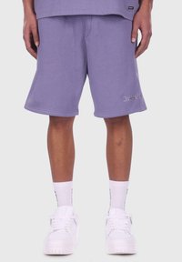 Lila Baumwollshorts mit elastischem Bund, ausgestattet mit einer seitlichen Nahttasche und "Dripsid" in Silber auf dem unteren Bein gestickt.