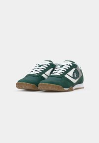 Adidași din suede verde cu accente din piele albă și talpă din cauciuc de tip gumă. Prezintă un design cu șireturi și o formă a vârfului rotunjită.