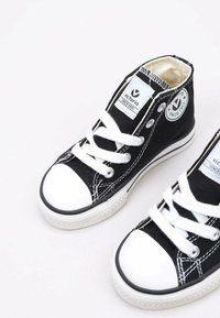 Zwarte canvas hoge sneakers met een witte rubberen teenkap en zool, voorzien van witte veters en een logopatch aan de zijkant.