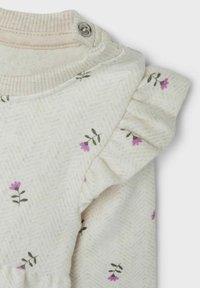 Tessuto chiaro con una sottile trama a spina di pesce, caratterizzato da piccoli motivi floreali viola e un dettaglio con maniche cornice.