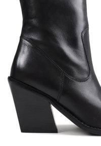 Black leather ankle boot with a glossy finish, featuring a pointed toe and a chunky, geometric heel. Seam detailing enhances the design.