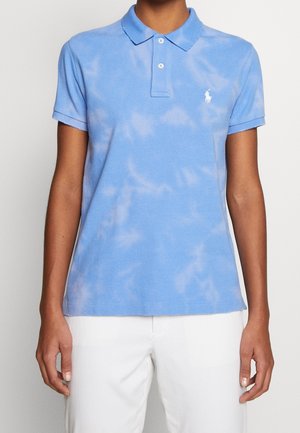 Jasnoniebieska koszulka polo z bawełnianej tkaniny z wzorem tie-dye. Posiada kołnierzyk, rozcięcie na dwa guziki oraz małe haftowane logo.