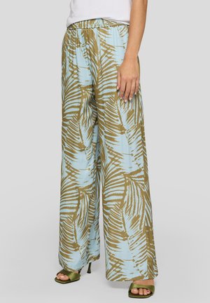 Hose mit weitem Bein und abstrakten hellblau-braunen Blattmustern, getragen mit grünen Sandaletten mit Absatz und einem weißen Top.