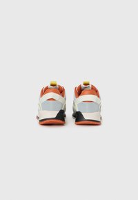 Pair of low-top sneakers with orange, gray, white, and black accents, viewed from the back, on a plain white background.