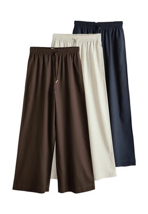 Trois pantalons à jambes larges avec tailles élastiques et cordons, en marron foncé, beige et bleu marine, superposés côte à côte.