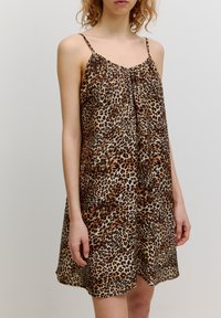 Leopardenmusterkleid mit dünnen Trägern. Besitzt einen lockeren Schnitt, knielanges Design und eine glatte, leichte Stofftextur.