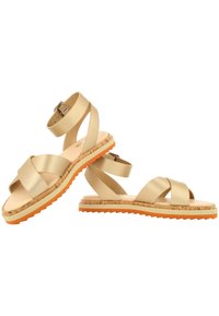 Sandalias beige con tiras cruzadas y plantilla de corcho, suela ligera y suela de goma naranja. Incluye una correa ajustable en el tobillo.