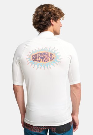 Biały krótki rash guard z kolorowym wzorem promieni słonecznych i napisem "Billabong" na plecach. Gładka tkanina o dopasowanym kroju.