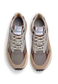 Zapatillas con una mezcla de ante gris y beige, paneles de malla y acentos marrones. Diseño con cordones y parche con logo en la lengua.