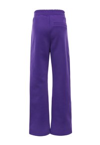Paarse wijdvallende sweats met een elastische tailleband en een enkele achterzak, gemaakt van een zachte stof met een gladde textuur.