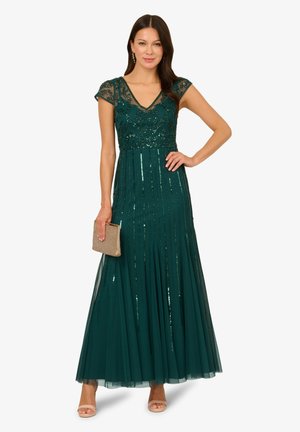 Teal Abendkleid mit kurzen, durchsichtigen Ärmeln, paillettenbesetztem Oberteil und fließendem Rock mit vertikalen Streifen. Enthält eine goldene Clutch.