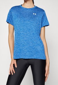 Blue athletic t-shirt made of lightweight, moisture-wicking fabric. Features a crew neckline and short sleeves, with a small white logo on the chest.