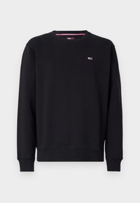 Sudadera negra de cuello redondo con mangas largas y un pequeño logo rectangular en rojo, blanco y azul en la parte superior izquierda del pecho.