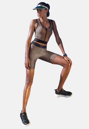 Athletic outfit featuring a fitted, zippered brown top with a subtle pattern and matching shorts. Black sporty sneakers enhance the look.