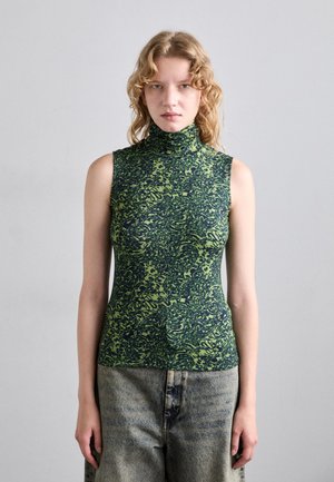Green sleeveless turtleneck top featuring a textured pattern with darker green swirls, paired with loose, light denim pants.