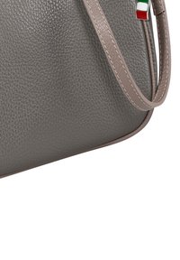 Gray textured leather handbag with a smooth, slightly curved shape. Features a light gray strap and a small Italian flag detail.