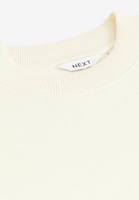 Cremfarbener Sweatshirt mit einem gerippten Rundhals. Verfügt über ein gewebtes Etikett mit dem Text "NEXT". Weicher Stoff mit einer glatten Textur.