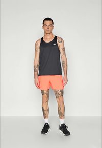 Must have mustela särk ilma varrukat ja ereoranžid lühikesed püksid, sportlik lõige, valmistatud kergest kangast, millel on rindkere peal logo.