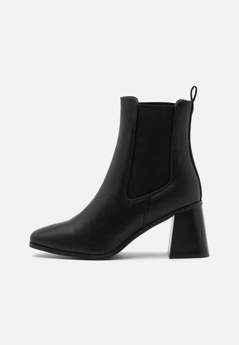 Bottine en cuir noir avec talon épais, panneaux latéraux élastiques, languette à l'arrière et bout pointu, vue de profil sur fond blanc.