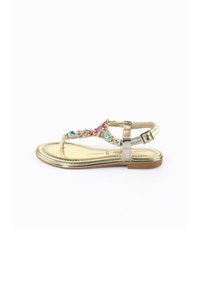 Sandali flat dorati con un design decorativo caratterizzato da gioielli multicolori e una cinghia metallica. Forma elegante con una cinghia alla caviglia regolabile.
