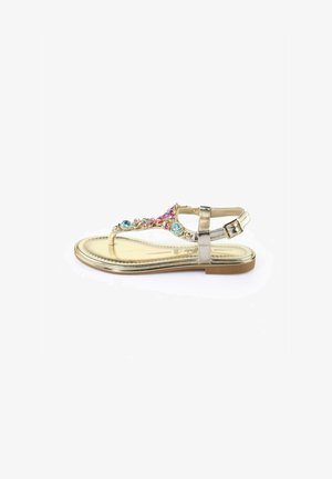 Gold flat sandal with a decorative design featuring multi-colored jewels and a metallic strap. Stylish shape with a buckled ankle strap.