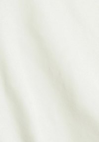 Tela color crema claro con una textura suave y un sutil tejido diagonal, que muestra patrones suaves similares a sombras en toda su superficie.