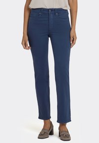 Marineblauwe jeans met een slimfit ontwerp, voorzien van voorzakken en een knoopsluiting. Gemaakt van een zachte katoenmix met een gladde textuur.